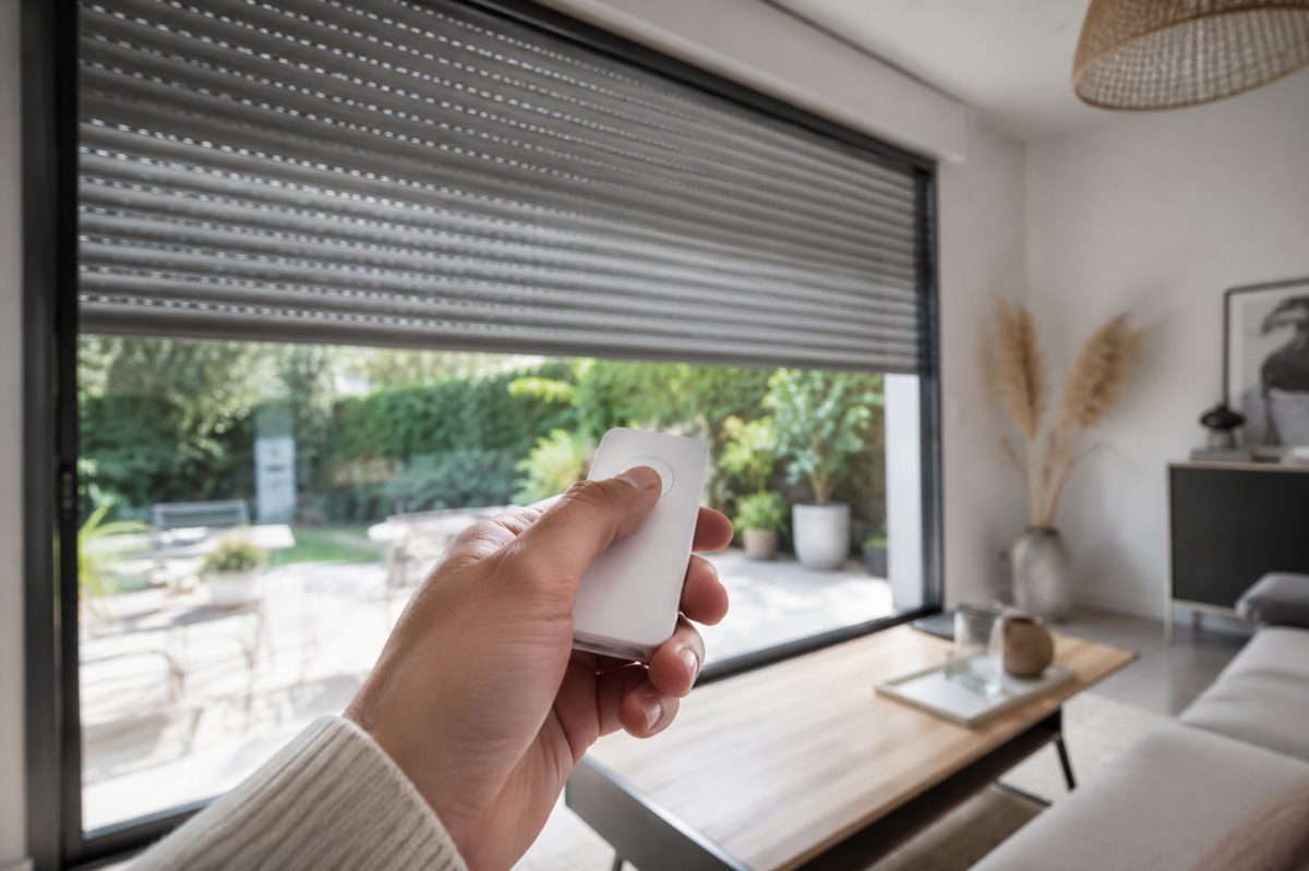 Persiana eléctrica controlada con un mando a distancia en un salón moderno